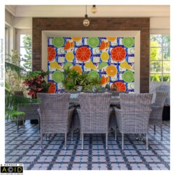 Garden room dining area featuring citrus slice wallpaper as a statement feature wall by Lisette Niemand, with bold orange, lemon and lime motifs in a Mediterranean inspired repeat.