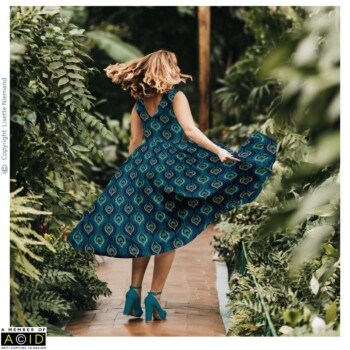 Fashion & Accessory Designs 2 Women’s dress design by Lisette Niemand featuring Peacock Indulgence from the Bohemian Spirit Collection, shown in a fashion mock-up. Features a flowing summer dress with repeating peacock feather pattern in teal, green, and magenta tones.