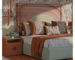 Southwestern bedroom interior featuring Wanderlust Cacti wallpaper, coordinated bedding and cushions by Lisette Niemand in terracotta, sage green and warm neutral tones.
